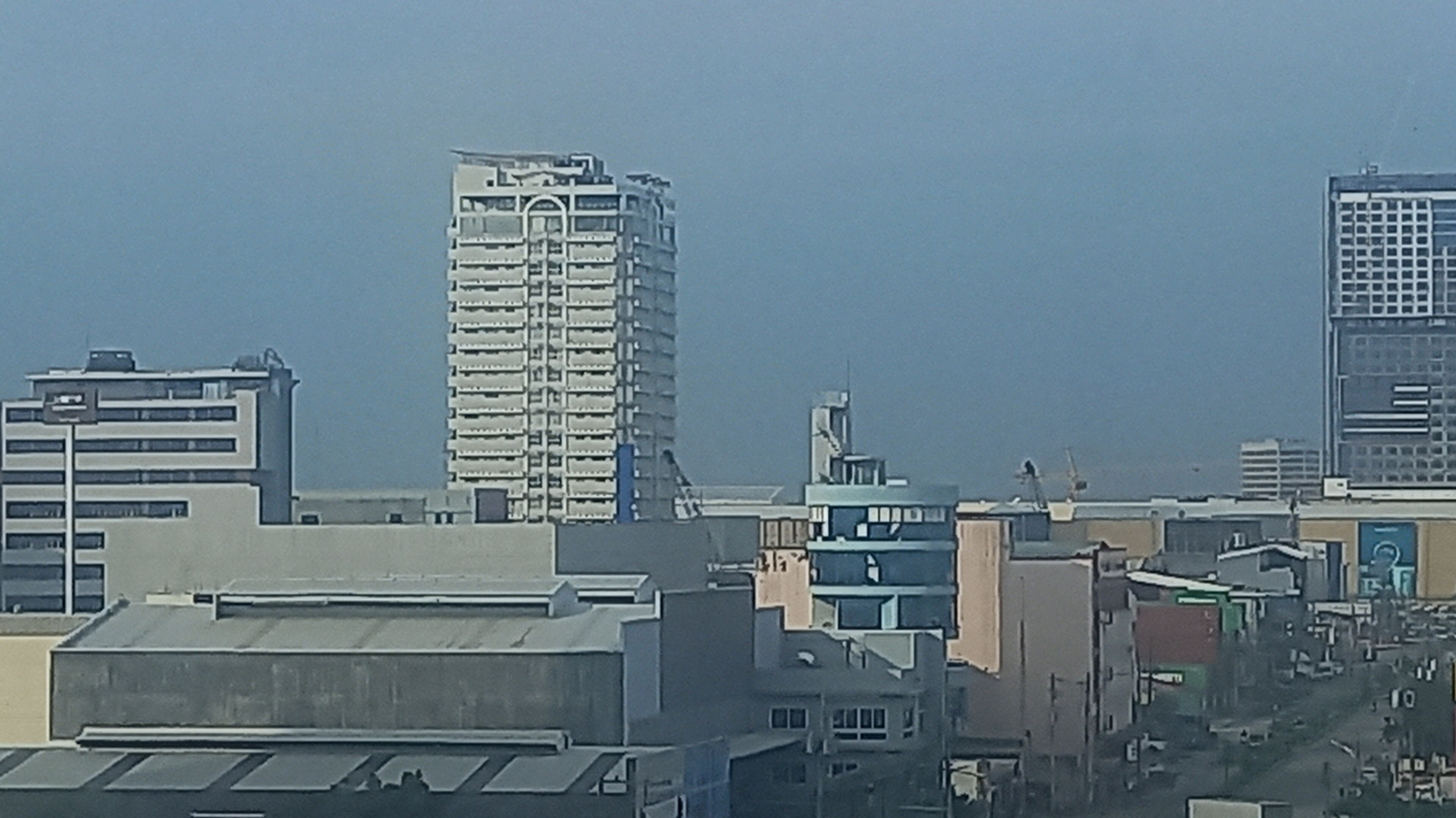 Un paisaje urbano con varios rascacielos, incluyendo un edificio alto destacado con fachada de entramado.