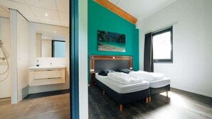 A modern bedroom with a bed, a nightstand, a mirror, and a window. - Holiday home for group with sauna and pool (Havelte)