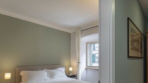 A bedroom with a bed, bedside lamps, a window, and a framed picture on the wall. - San Lorenzo View by Wonderful Italy (Genoa)