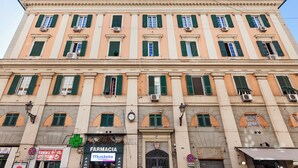 A multi-story building with a row of shops on the ground floor, including a pharmacy. - San Lorenzo View by Wonderful Italy (Genoa)