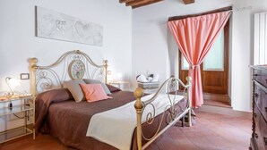 A bedroom with a bed, bedside tables, a nightstand, a dresser, and a window with curtains. - Stunning  villa with pool, WIFI, TV, terrace and panoramic view, close to Greve In Chianti (Gaiole In Chianti)