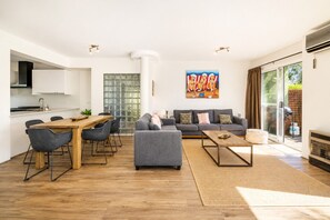 A modern living space with a dining area, sofa set, and artwork. - Abby's Beach Villa (Broadwater)