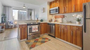 Una cocina moderna con armarios de madera, electrodomésticos de acero inoxidable y salpicadero de azulejos.