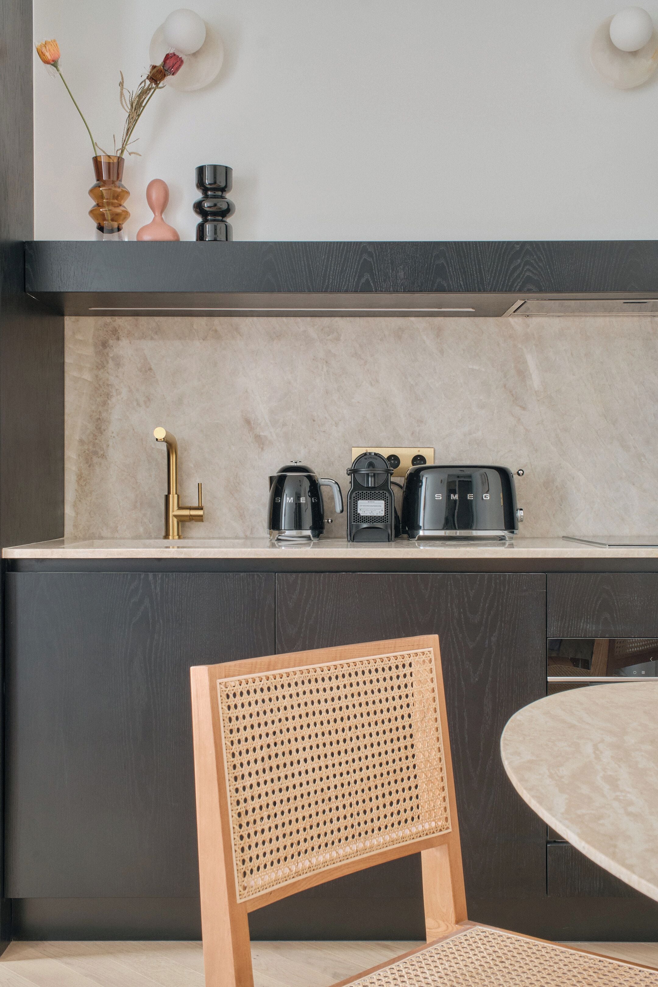 A modern kitchen with a marble countertop, a gold faucet, a coffee maker, and a toaster.