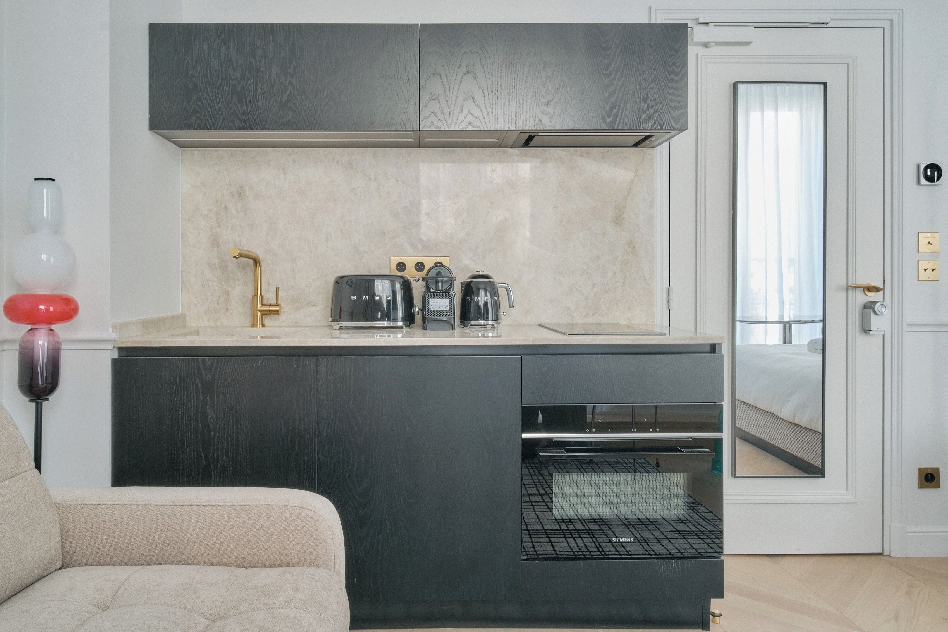 A compact kitchen with a built-in oven, a coffee maker, and a toaster.