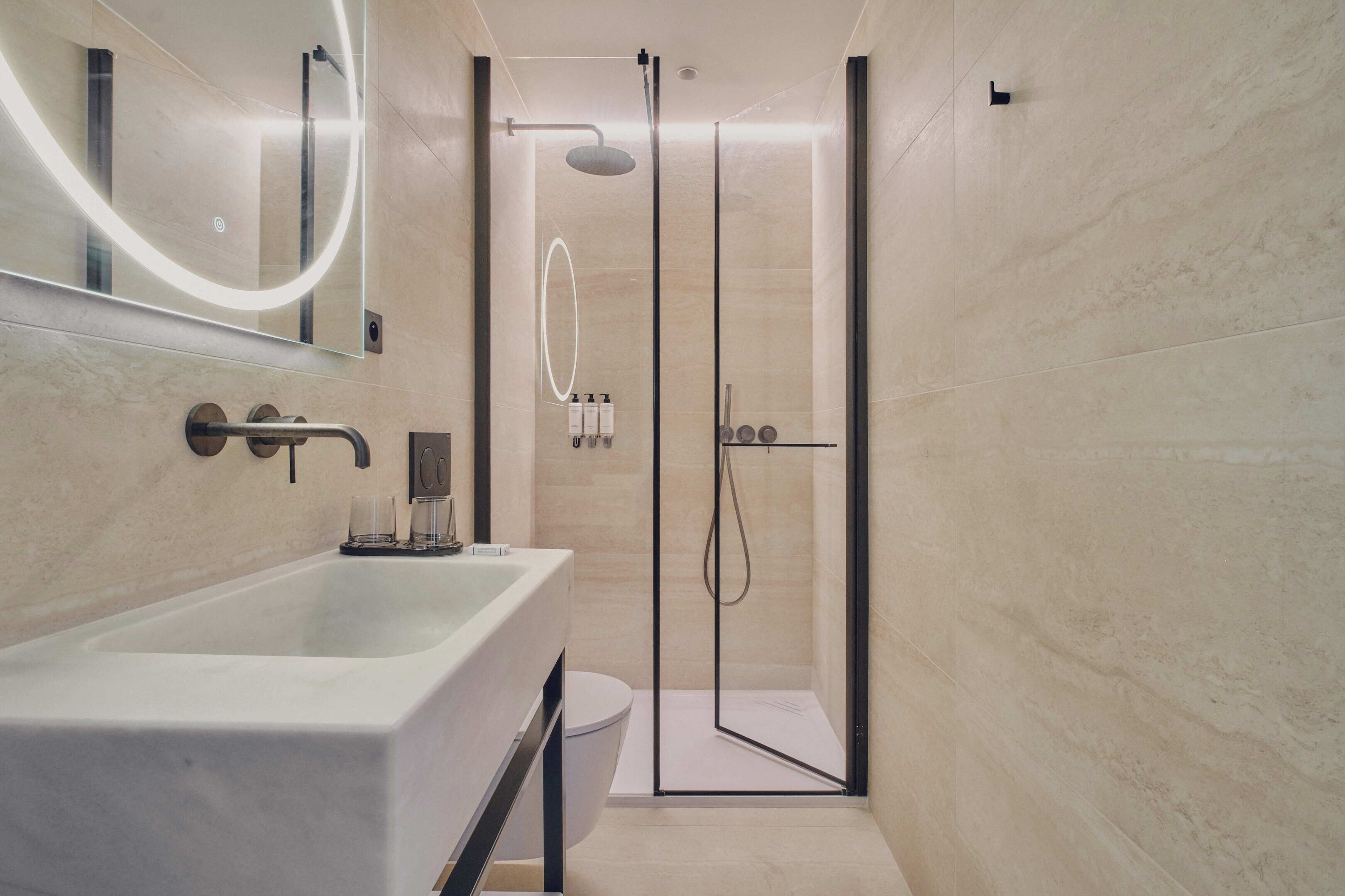 A modern bathroom with a large bathtub, a glass-enclosed shower, and a toilet.