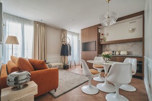A modern living room with a sofa, chairs, a coffee table, and a TV. - Nestay Les Halles (Paris)