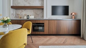 A modern kitchen with a marble backsplash, wooden cabinets, and a built-in oven. - Nestay Les Halles (Paris)