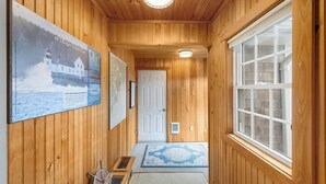 A wooden hallway with a door, a window, and a poster on the wall. - Sand Cove Cottage-New! (Gouldsboro)
