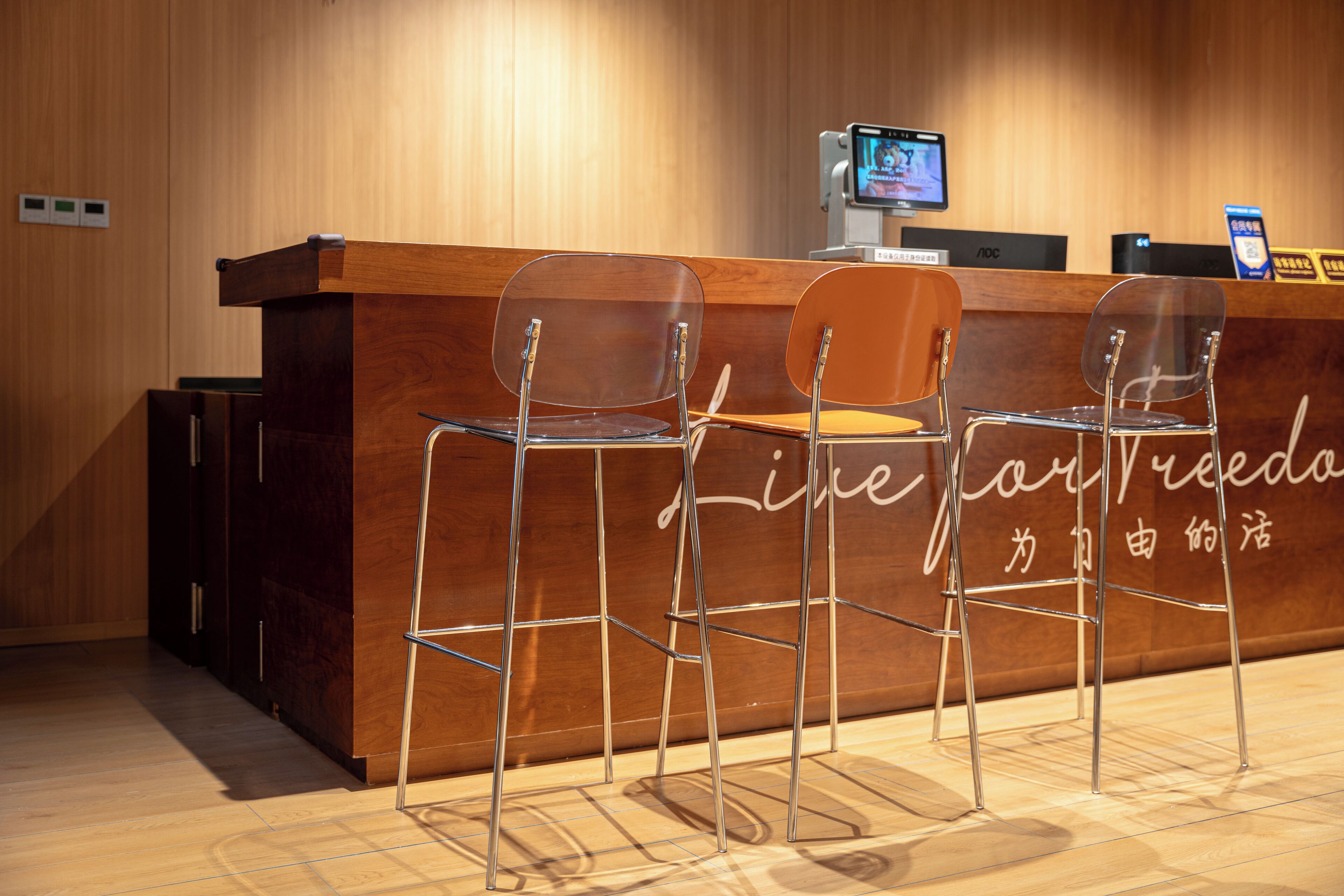A reception desk with two clear chairs and a wooden counter.