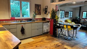 Eine moderne Küche mit einer Holz Arbeitsplatte, grauen Schränken und einem großen Fenster.