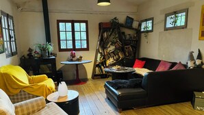 Ein gemütliches Wohnzimmer mit Kamin, Bücherregal und Esstisch.