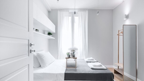 A modern bedroom with a bed, bedside table, and a large mirror. - Easylife -Modern and elegant in the heart of Milan (Milano)