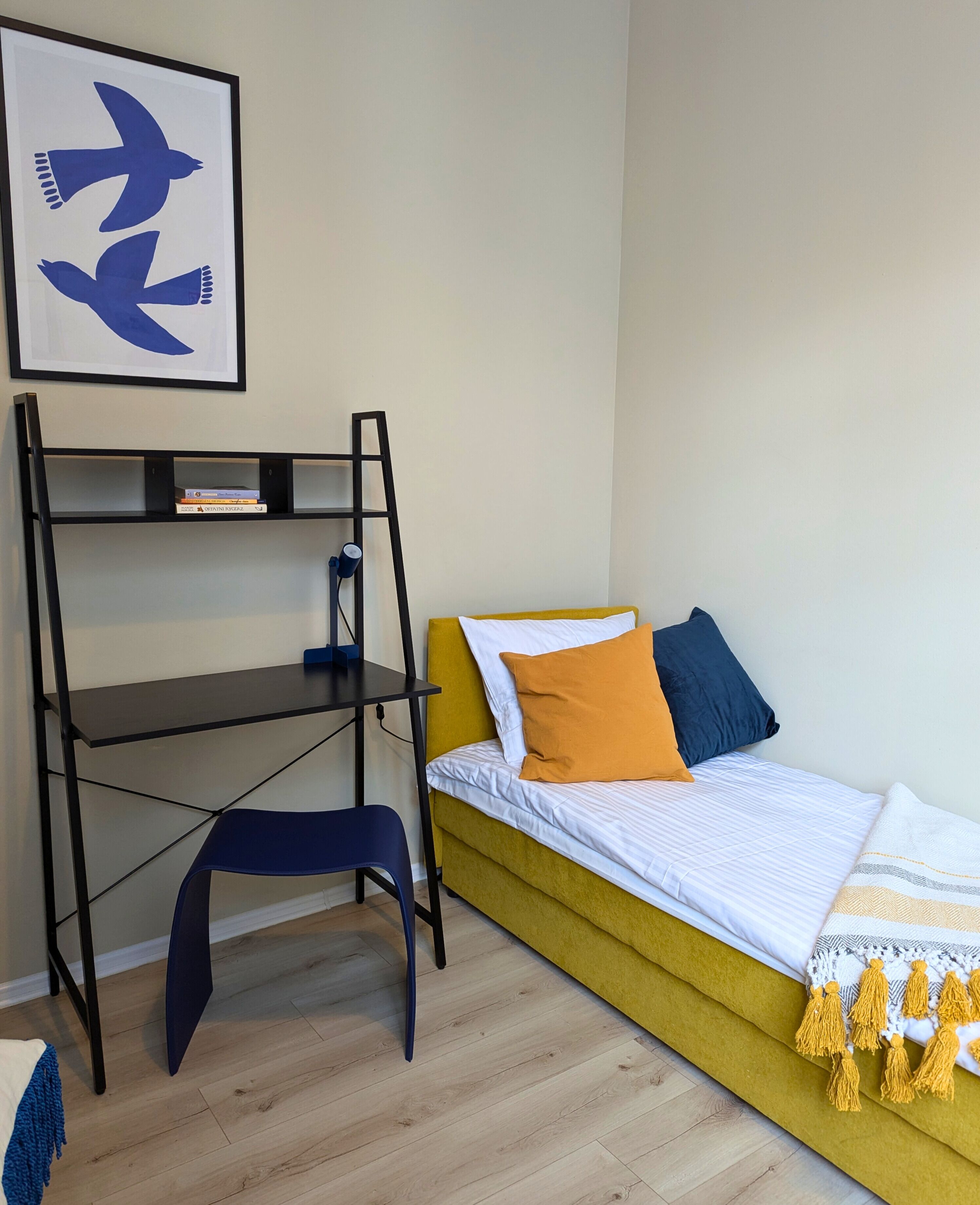 A room with a bed, a desk, and a bookshelf.