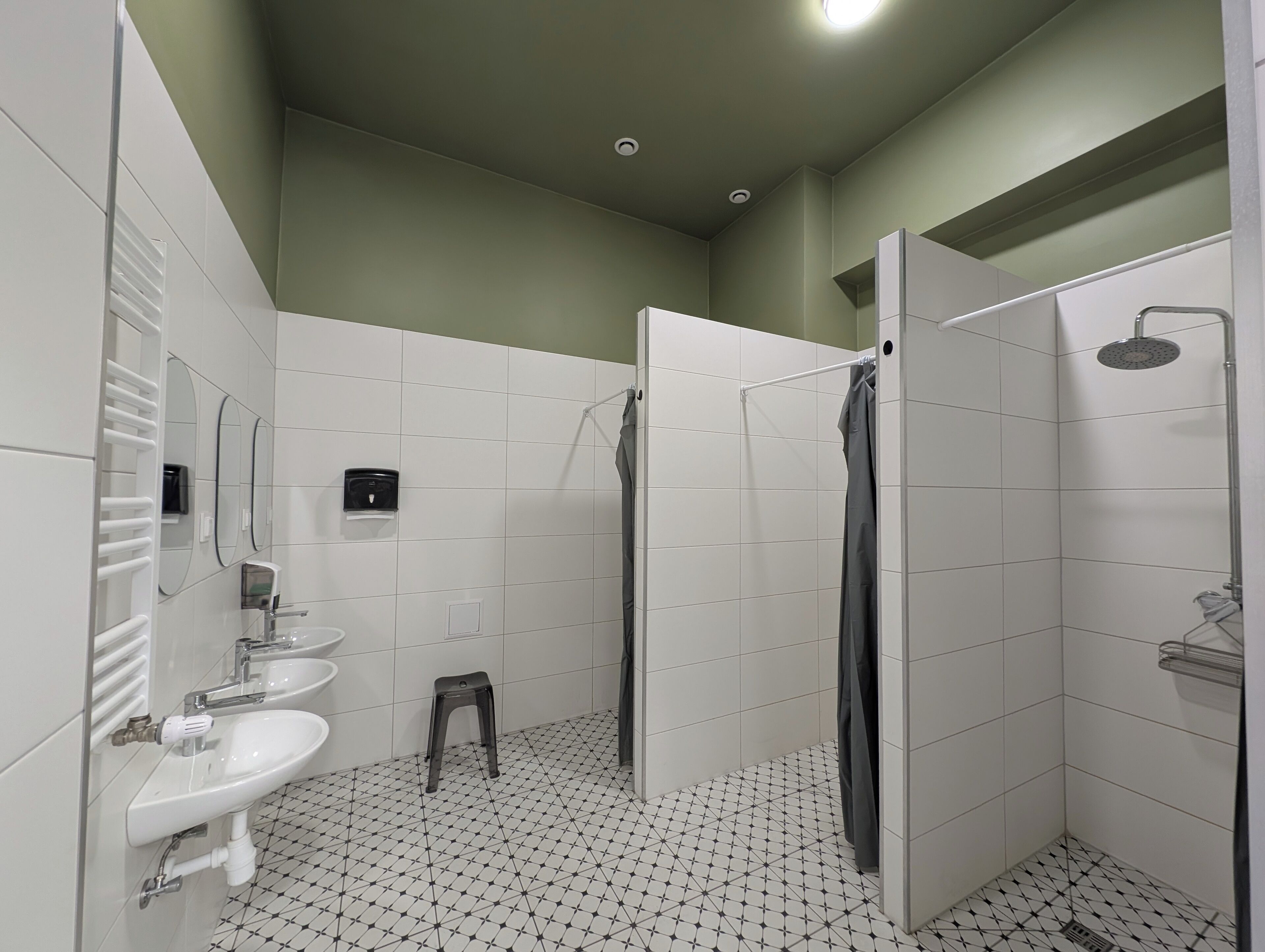Une salle de bain moderne avec un lavabo blanc, un miroir et un espace douche.