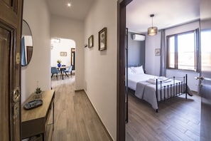 Ein Hotelzimmer mit einem Bett, einem Schreibtisch mit Computer, einem Sessel und einem Fenster mit Vorhängen.