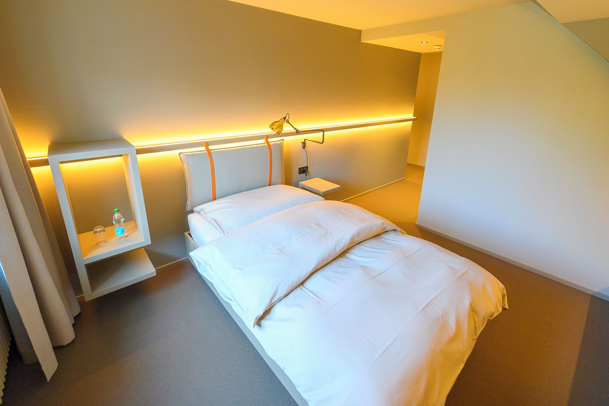 Ein Hotelzimmer mit Bett, Nachttischen und einem Nachtschränkchen.