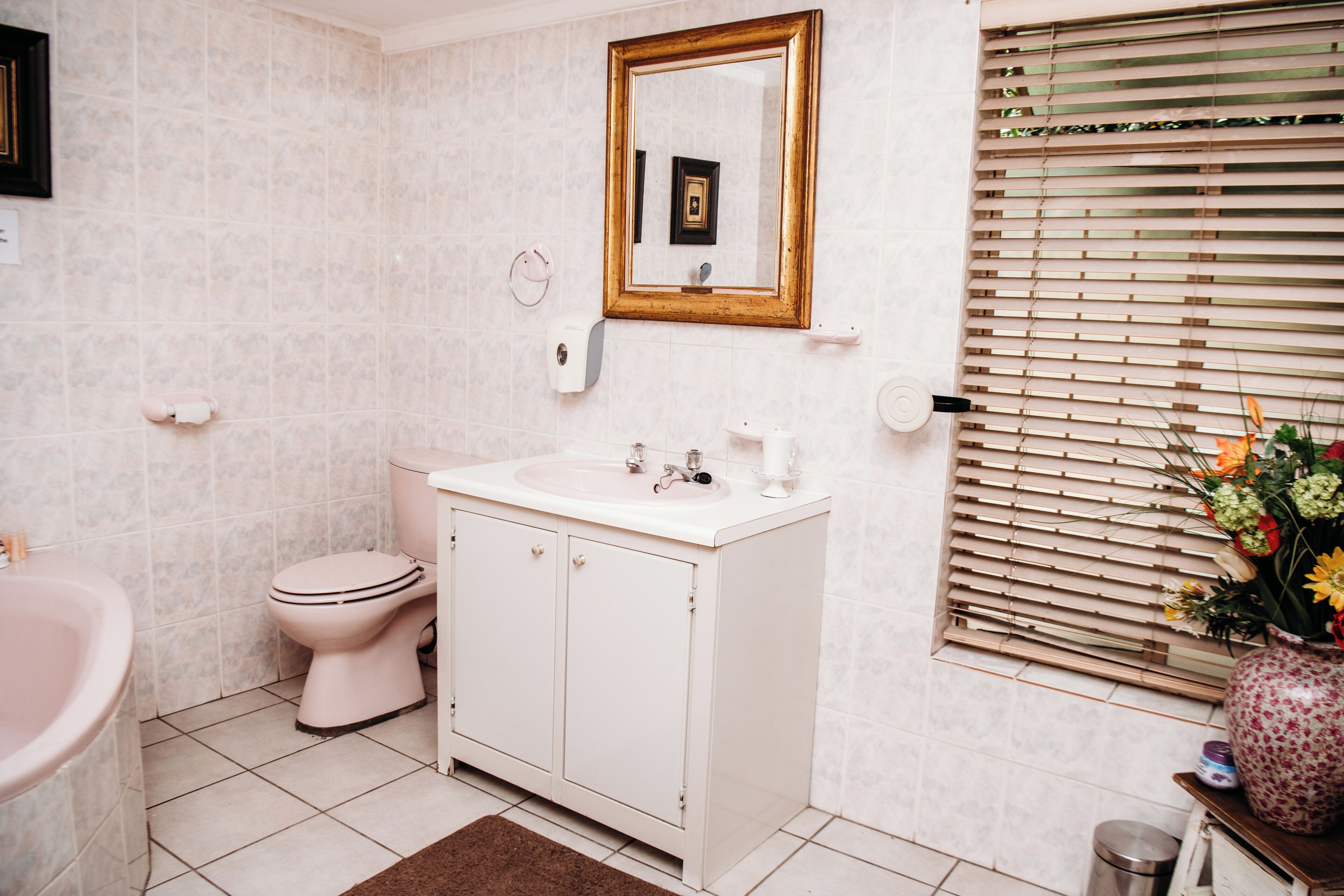 A bathroom with a white sink, toilet, and vanity.