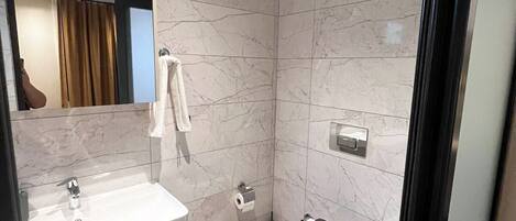 A modern bathroom with a white sink, a toilet, and a mirror.