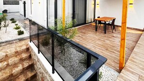 A modern house with a wooden deck, a glass railing, and a stone wall. - Villa Zena Demre (Demre)