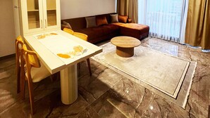 A modern living room with a dining area, a sofa, a coffee table, and a large window with curtains. - Villa Zena Demre (Demre)