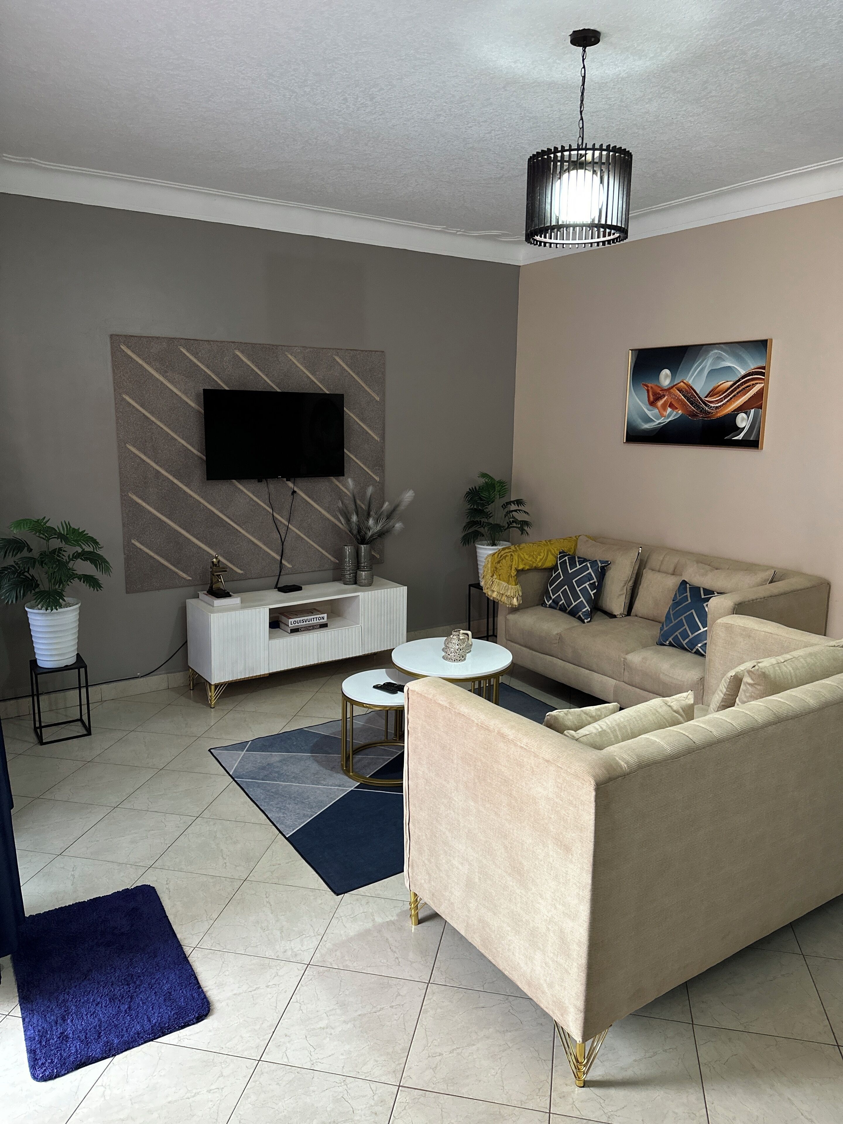 Un salon comprenant un canapé, une table basse, un téléviseur et des objets de décoration.