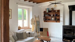 Ein gemütliches Wohnzimmer mit einem weißen Sofa, einem Holztisch und einem Kamin.