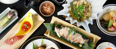 Variedad de platos japoneses, como sushi, sashimi y cazuelas de arroz.
