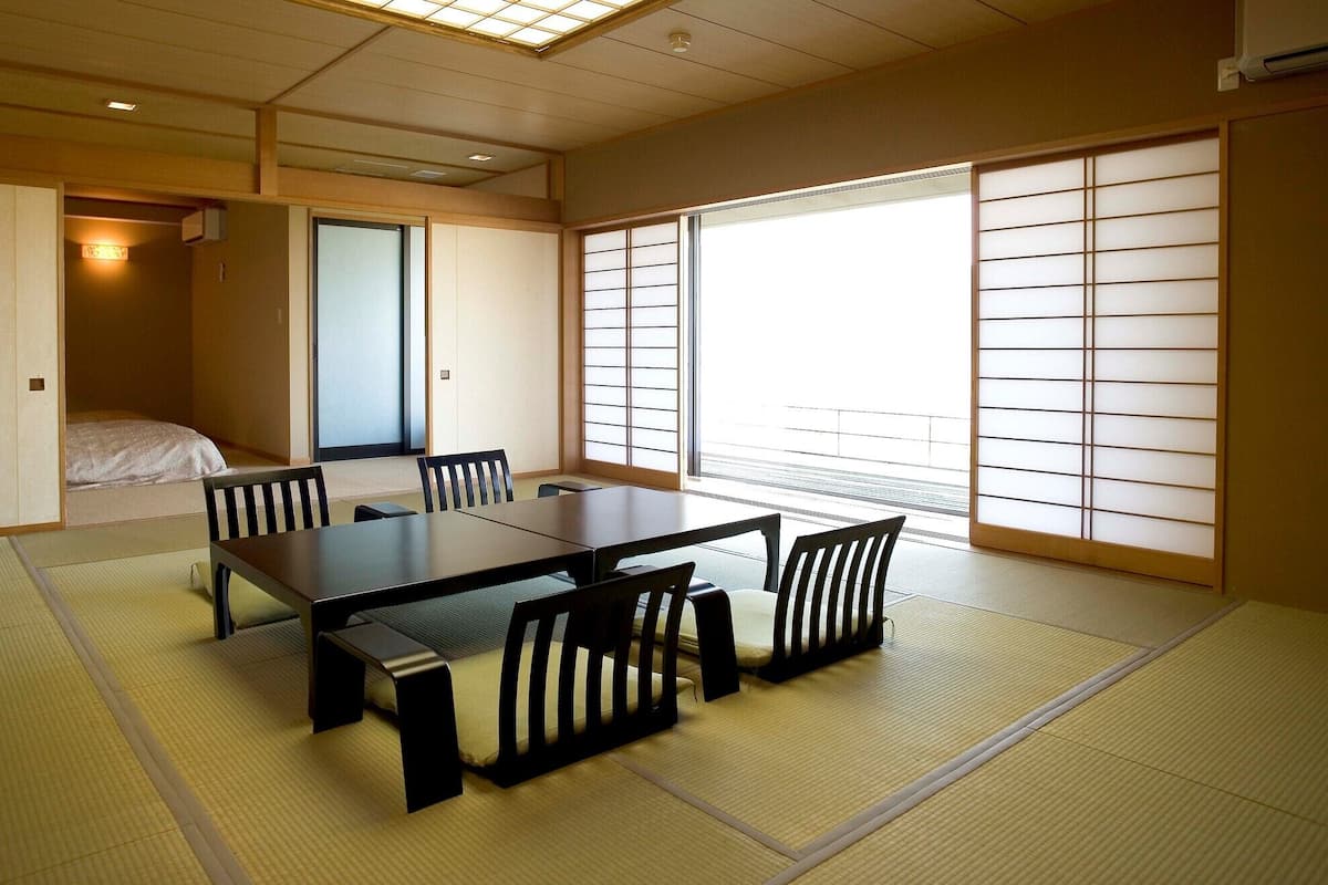 Een traditionele Japanse kamer met tatami vloeren, een lage tafel en schuifdeuren.