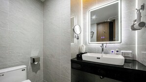 A modern bathroom with a white toilet, a black sink, and a mirror. - A25 Premium Hotel - 21 Nghia Tan (Hanoi)