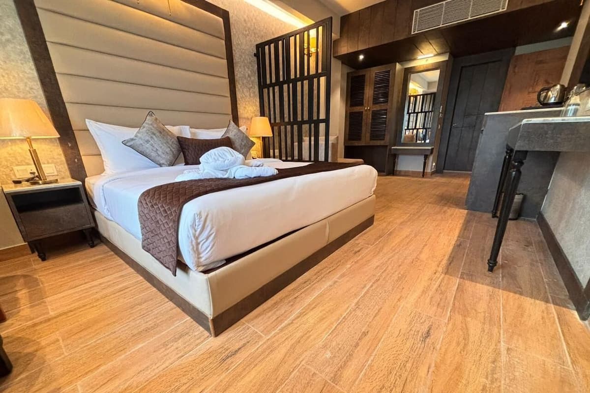 Une chambre d’hôtel moderne dotée d’un grand lit, d’un parquet, d’un bureau et d’une armoire.
