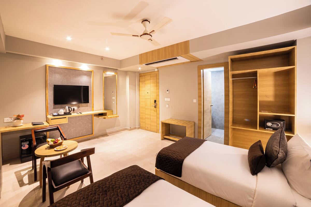 Une chambre d’hôtel équipée d’un lit, d’un bureau, d’une chaise, d’une télévision et d’une armoire.