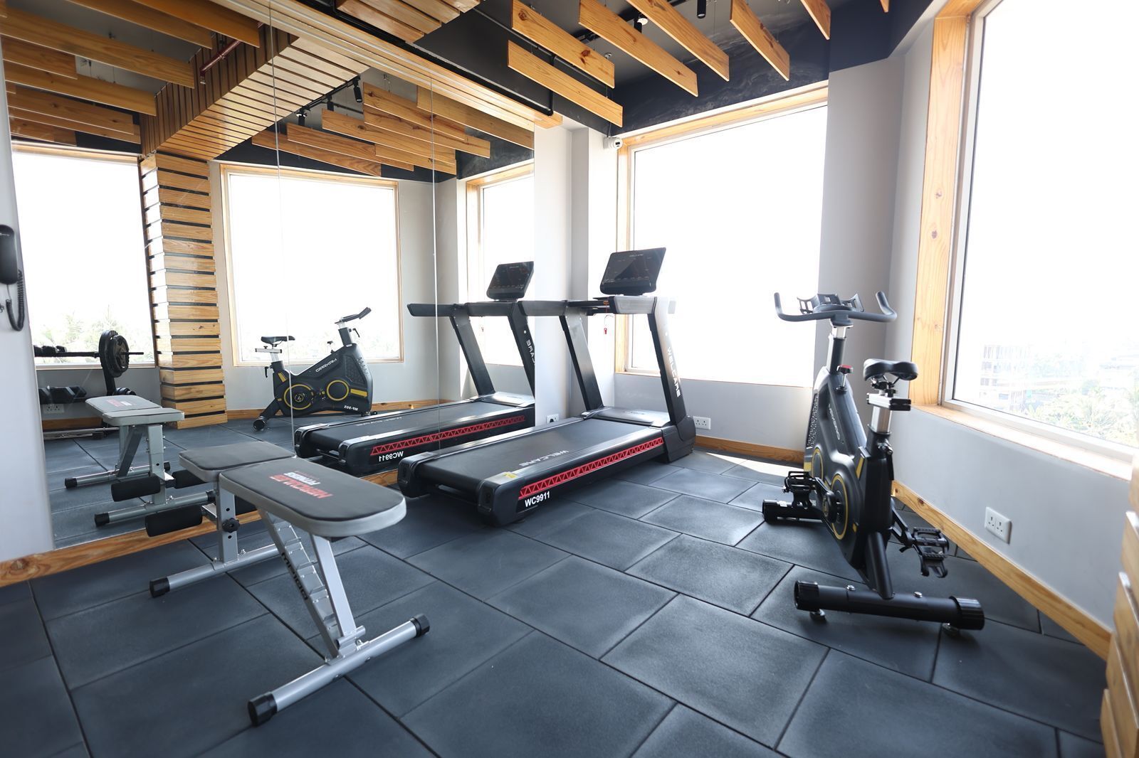 A gym with treadmills, a stationary bike, and weightlifting equipment.