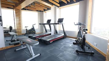 A gym with treadmills, a stationary bike, and weightlifting equipment.