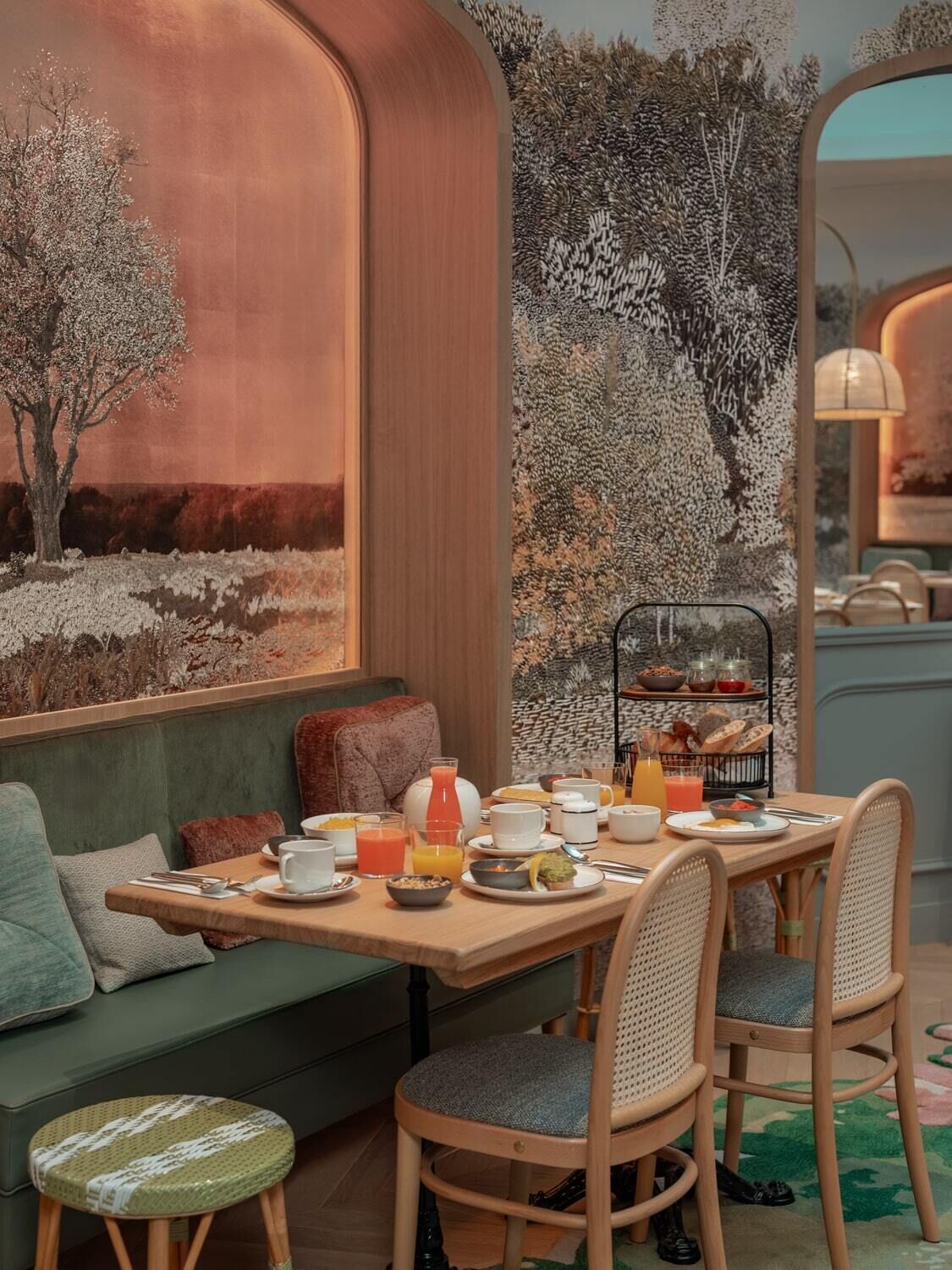 A cozy breakfast setting with a table set for two, a sofa, and a small stool.
