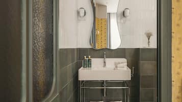 Une salle de bain avec un lavabo blanc, un miroir et un porte-serviettes.