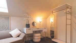 A modern bedroom with a bed, a desk with a mirror, and a wardrobe. - Howfield Hotel (Merthyr Tydfil)