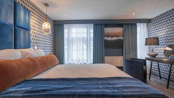 Habitación de hotel moderna con una cama grande, un escritorio y vistas al exterior.