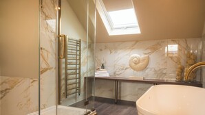 A modern bathroom with a glass-enclosed shower, a freestanding bathtub, and a skylight. - Howfield Hotel (Merthyr Tydfil)
