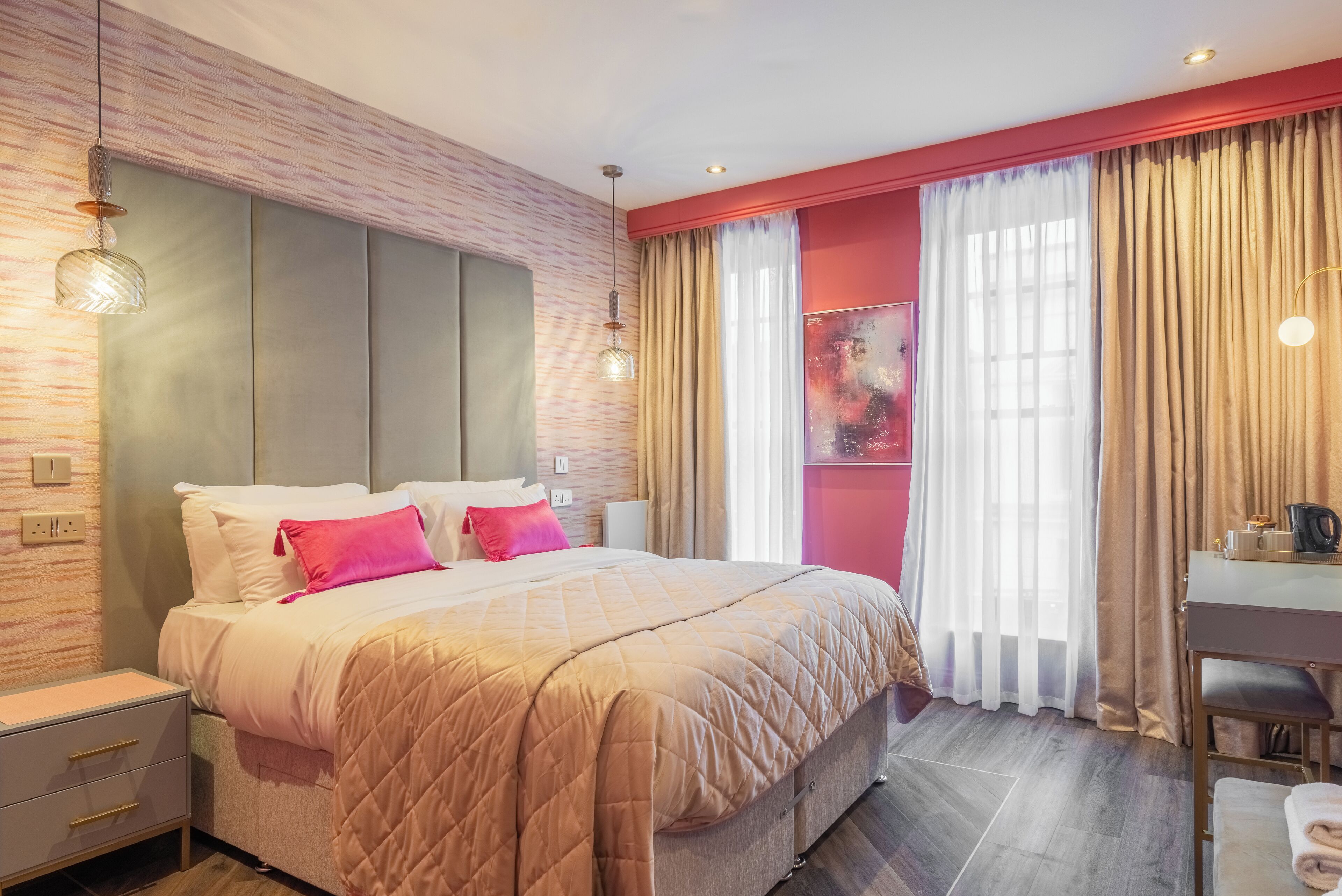 Een moderne slaapkamer met een groot bed, nachtkastjes, een bureau en een stoel.