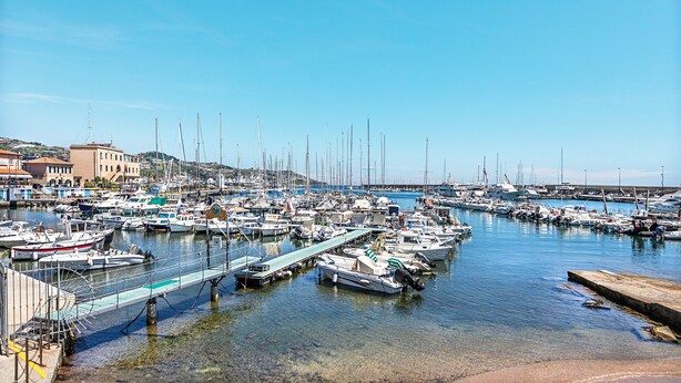 A marina with numerous boats docked, a clear sky, and buildings in the background. - Gaudio Charming Apartment by Wonderful Italy (Sanremo)