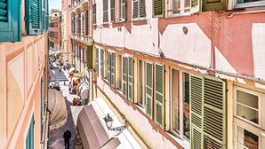 A narrow street with buildings featuring multiple stories, balconies, and shutters. - Gaudio Charming Apartment by Wonderful Italy (Sanremo)