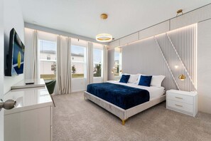 Una camera da letto moderna con un letto, comodini, una TV e vista sull'esterno.