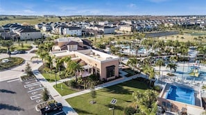A residential area with houses, a swimming pool, and a parking lot.
