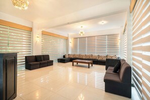 A spacious living room with a sectional sofa, a coffee table, and a TV. - Lavendish Tamarind Lifestyle (Kataragama)