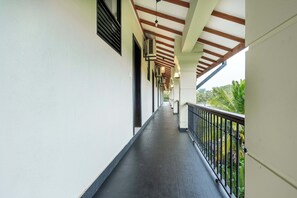 A covered corridor with a dark floor, white walls, and a railing on one side. - Lavendish Tamarind Lifestyle (Kataragama)