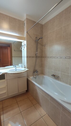 A bathroom with a bathtub, a sink, and a shower. - Sand, Sea and Salt - Alvor (Alvor)
