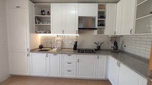 A modern kitchen with white cabinets, a granite countertop, a built-in oven, and a stainless steel sink. - Sand, Sea and Salt - Alvor (Alvor)