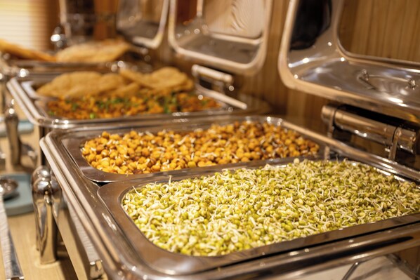 Un buffet proposant une variété de plats, notamment des germes et d’autres mets.