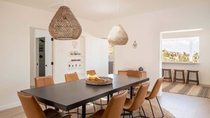 A modern dining area with a long table, brown leather chairs, and woven pendant lights. - Villa Paloma • 4-Acre Stylish Retreat with Hot Tub (Yucca Valley)